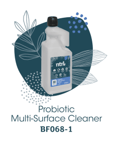 A 1-litre bottle of ntrl Probiotic Multi-Surface Cleaner (BF068-1) with a blue label, displayed against a decorative background with illustrated leaves and dots.